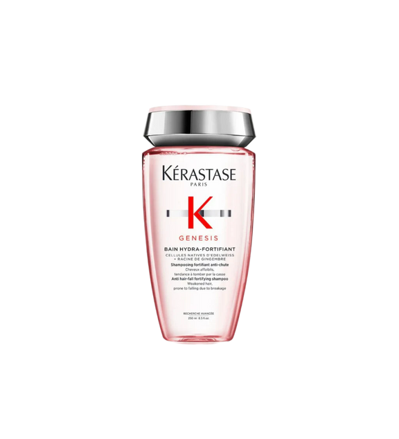 A bottle of **Kérastase Genesis Bain Hydra-Fortifiant**, a lightweight fortifying shampoo designed for thin, weakened hair prone to hair fall due to breakage. The sleek, blush pink packaging highlights its gentle, cleansing formula, enriched with Edelweiss Native Cells and Ginger Root, to strengthen, purify the scalp, and improve resilience while maintaining softness and hydration.
