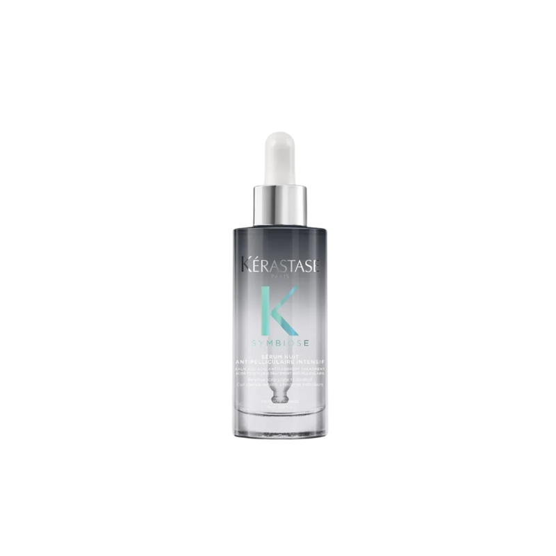 A bottle of **Kérastase Symbiose Cellulaire Nuit Anti-Dandruff Scalp Serum Intensif**, a luxurious overnight treatment designed to soothe the scalp and target dandruff at its source. Its lightweight formula works while you sleep to restore balance, providing long-lasting comfort and hydration.