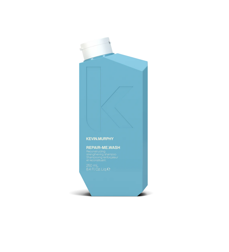 A bottle of **KEVIN.MURPHY REPAIR-ME.WASH**, a reconstructing shampoo designed to strengthen and restore damaged or over-processed hair. Infused with proteins and nourishing ingredients, it gently cleanses while helping to rebuild and fortify hair, leaving it soft, smooth, and healthy.