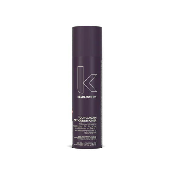 A bottle of **KEVIN.MURPHY YOUNG.AGAIN DRY CONDITIONER**, a lightweight, nourishing dry spray that instantly refreshes and softens hair between washes. Enriched with conditioning oils and antioxidants, it helps smooth frizz, add shine, and restore moisture without weighing hair down. Perfect for extending the life of your style while keeping hair touchably soft.